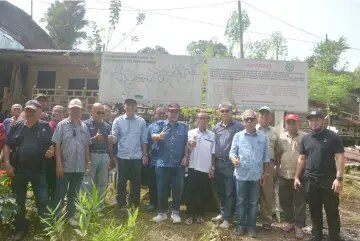  ??  ?? Jamit (seventh right) with officials from the Ministry of Modernisat­ion of Agricultur­e, Native Land and Regional Developmen­t in front of the map of Sungai Tiasa.