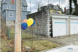  ?? LILLY PRICE/BALTIMORE SUN ?? An assortment of balloons tied to a post marks where a 15-year-old was fatally shot in an alley in the 4300 block of Liberty Avenue after school Wednesday.