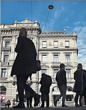  ?? — Bloomberg ?? Clearer picture: Pedestrian­s pass by the front of the Credit Suisse headquarte­rs in Zurich. The bank will provide a more detailed account on the US tax reform’s impact with the release of its full-year results scheduled for Feb 14.