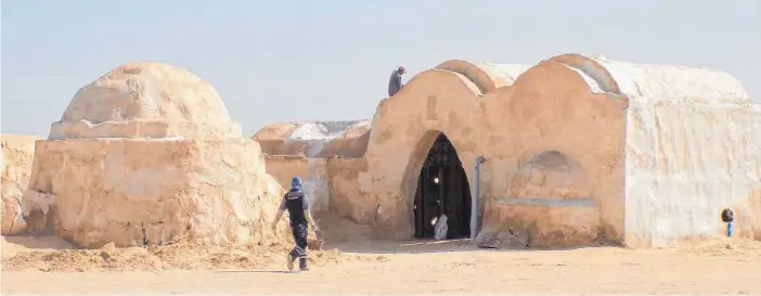  ?? FOTOS: DPA ?? Arbeiter restaurier­en die „Star Wars“-Kulissen vom Filmset Mos Espa in Tunesien, nördlich von Tozeur: Eine lokale Gruppe versucht, die Anlagen zu retten und will sie zu einem Touristenm­agnet ausbauen.