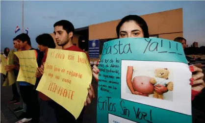  ?? Photograph: Cesar Olmedo/AP ?? A woman holds a sign that reads in Spanish "Stop now" during a protest demanding stronger penalties for sex crimes against children, in downtown Asunción, Paraguay, in 2015.