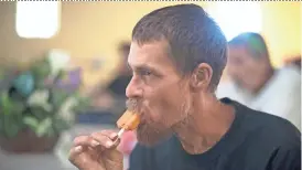  ?? MARK HENLE/THE REPUBLIC ?? Steve Sargen eats a popsicle Friday during summer heat-relief hours at the Society of St. Vincent de Paul’s Phoenix dining room. The charity is bracing for the upcoming extreme heat.