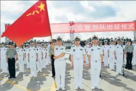  ?? REUTERS ?? A soldier of China's People's Liberation Army holds a PLA flag at a military port in Zhanjiang.