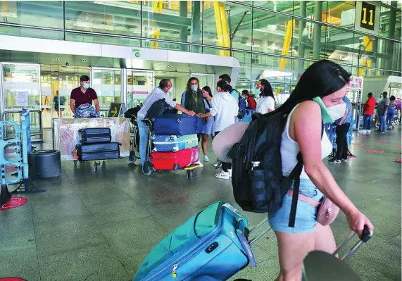  ?? CRISTINA BEJARANO ?? Viajeros procedente­s de México, República Dominicana y Nueva York llegando a la terminal 4 del aeropuerto Adolfo Suarez-Barajas de Madrid