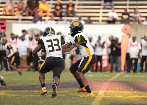  ?? (Special to The Commercial/Alcorn State University) ?? Golden Lions quarterbac­k Skyler Perry (right) hands the ball to Kayvon Britten during first-half action Saturday night against Alcorn State University at Lorman, Miss.