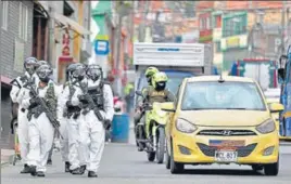  ?? AP ?? BOOTS ON THE GROUND: Soldiers in protective gear patrol the streets of the bustling neighbourh­ood of Ciudad Bolivar, an area with high cases of the coronaviru­s, in Bogota, Colombia.