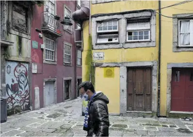  ?? Miguel Riopa / AFP ?? Un hombre con mascarilla camina por las calles vacías del centro de Oporto, la semana pasada.
