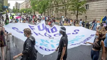  ?? Alexandra Wimley/Post-Gazette ?? Marching protesters hold a banner that reads "Fund schools not prisons freedom to thrive" during a rally to demand police officers are removed from Pittsburgh public schools Monday outside the Pittsburgh Board of Education building in Oakland.