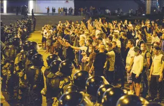  ?? Associated Press ?? Police confront protesters late Sunday in the capital of Minsk. President Alexander Lukashenko vowed to crack down on protests after claiming a sweeping reelection victory.