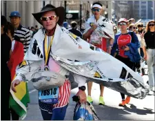  ?? CHRIS CHRISTO/BOSTON HERALD ?? Runners make their way down Stuart Street after finishing the marathon.