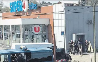  ?? NEWSFLARE/TARBOURIEC­H ROSELINE THE ASSOCIATED PRESS ?? Police gather outside a supermarke­t in Trebes, France, on Friday. An armed man took hostages there, killing three people before being slain. He had earlier opened fire on officers nearby.