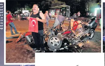  ??  ?? A man poses with the flag of Turkey in front of a damaged car, crushed by a military tank, as people gather in Kizilay Square to protest against the military coup