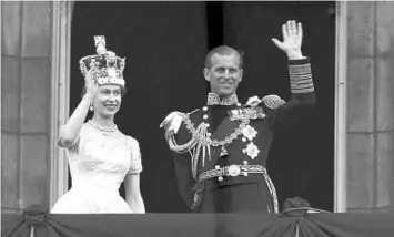  ??  ?? Britain’s Queen Elizabeth II and her husband, Prince Philip, wave from Buckingham Palace after her coronation. The palace announced that Philip died Friday at 99 and less than a month after being released from a hospital.
