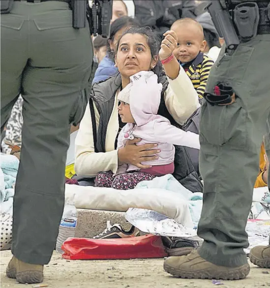  ?? ?? Vigilancia. Una madre migrante enseña a la patrulla fronteriza la pulsera que muestra que está en espera en la frontera con Estados Unidos.