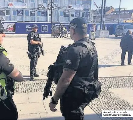  ??  ?? Armed police outside Cardiff Central yesterday