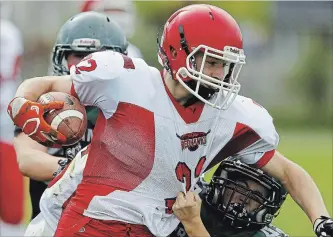  ?? CLIFFORD SKARSTEDT EXAMINER ?? Holy Cross Hurricanes’ Colby Cummings moves in on Haliburton Highlands Redhawks’ Kyle Cooper during senior boys football game action on Oct. 5 at Holy Cross field.