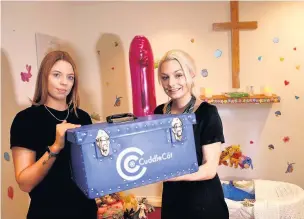  ??  ?? Katie Hoult, left, presents the cuddle cot to Stacey Booth of GW Turners funeral directors Andy Lambert