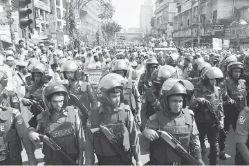  ??  ?? Bangladesh­i police stand guard as activists from Islamic organisati­ons march towards the Myanmar embassy in Dhaka to protest against the persecutio­n of Rohingya Muslims in Myanmar. — AFP photo