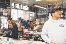  ??  ?? Customers look through the collection at Wax Trax on Oct. 31.