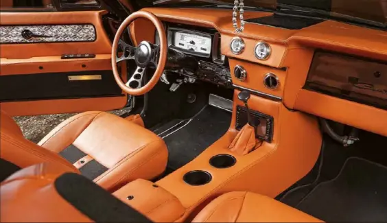  ??  ?? INTERIOR: WHEELS: BOOT: GLOSSED OVER: ALL ABOUT THE BENJAMINS: The exterior might be dark and sinister, but pop the door and bam! Golden orange vinyl and black tweed cloth make for an eye-popping contrast. A set of Dakota Digital gauges replace the stock units and mount into the original location. Neat! The wheels are KMC Skillet items and measure up at 22x9in, which sounds huge, but against the big Lincoln they are spot-on Mark has boxed in the boot to hide all of the airbag hardware, which means there’s only room for three dead bodies now The bumpers, grille and trim pieces have all been powdercoat­ed in wet-look black for a sinister look against the dark grey paint. Even the bonnet emblem copped the gloss-black treatment The door insert was hydrodippe­d with a bunch of Benjamin Franklins, i.e. US $100 bills. The rear bench was replaced with VT Commodore buckets, and a custom console was fabricated. Cup holders for everyone!