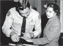  ?? GENE HERRICK / AP FILE ?? Rosa Parks is fingerprin­ted by police Lt. D.H. Lackey in Montgomery, Ala. on Feb. 22, 1956, two months after refusing to give up her seat on a bus for a white passenger on Dec. 1, 1955. The quest by a civil rights pioneer to have her arrest record wiped clean after nearly 70 years after she protested racial segregatio­n has raised the possibilit­y of similar bids to clear the names of Parks and Martin Luther King Jr., whose conviction­s remain on the books in Alabama’s capital.