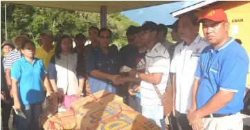  ??  ?? Jamit (third left) hands over cash assistance to Tuai Rumah Lorre.