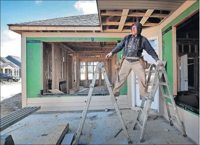  ?? [TOM DODGE/DISPATCH] ?? Lorenzo Sanchez works on the siding of a home being built in Jerome Village in Union County, which is now the state’s fastest-growing county by percentage.