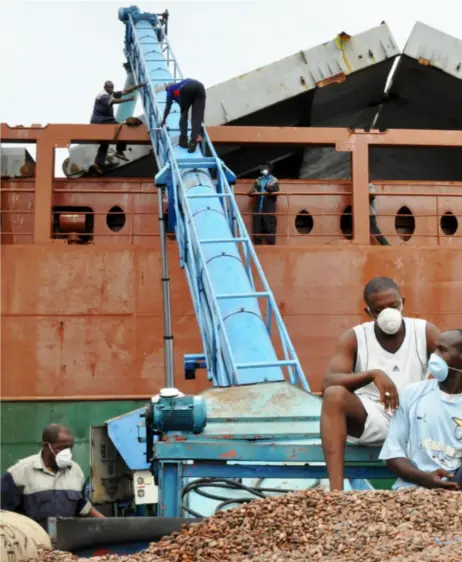  ?? BIBIANA DAHLE PIENE / SCANPIX ?? En eim av sjokolade henger over havnearbei­derne som sender sekk på sekk med kakaobønne­r opp i digre tankskip. 40 prosent av all kakao i verden kommer fra Elfenbensk­ysten.