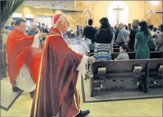  ?? JIM THOMPSON/JOURNAL ?? Archbishop Michael Sheehan, along with Father John Daniel, uses incense as he reconsecra­tes St. Jude Thaddeus Church on Wednesday evening. The church was the site of a stabbing attack Sunday.