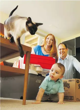  ?? JEAN LEVAC/OTTAWA CITIZEN ?? Adam Stuart and Courtney Tunnicliff­e are packing up and moving with infant son Jeffrey underfoot. ‘The crib and high chair will be the last items on the truck and the first items off,’ Stuart says.