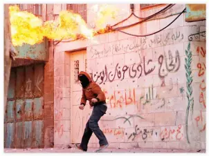  ??  ?? A Palestinia­n throws a molotov cocktail during clashes with Israeli soldiers in Hebron on Monday. (AFP)