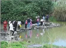  ?? CHINA DAILY PROVIDED TO ?? Top: Tourists walk on a stone bridge at the Wuyuan River National Wetland Park in Haikou, Hainan province, in February.