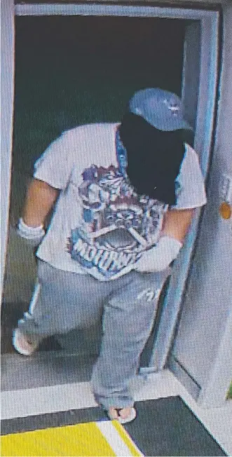  ??  ?? The ‘undies bandit’ enters Broadwater Pharmacy armed with a hammer on Monday night.