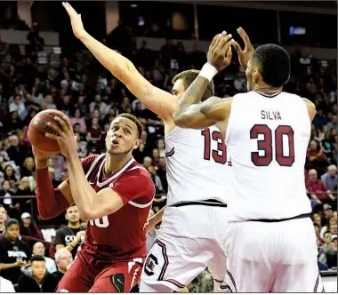  ?? Spurs and Feathers/ALLEN SHARPE ?? Arkansas forward Daniel Gafford tries to get around South Carolina’s Felipe Haase (13) and Chris Silva (30) on Saturday in Columbia, S.C. Gafford has drawn at least three fouls in four of the past five games.