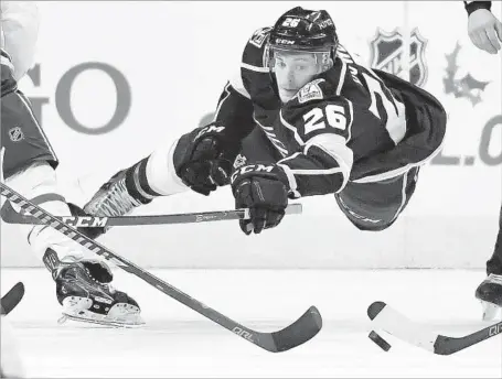  ?? Mark J. Terrill Associated Press ?? KINGS CENTER Nic Dowd makes an all-out dive for the puck as several other players try to control it during the second period.