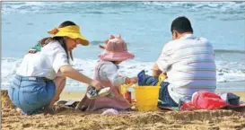  ?? ?? A family spends a relaxing time at the beach in Sanya, South China’s Hainan province, on Jan 4.