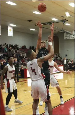  ?? The Sentinel-Record/James Leigh ?? STRETCHING OUT: Ouachita Baptist’s Isaiah Harper puts up a shot over Henderson State’s Josh Jones in the Battle of the Ravine at the Duke Wells Center at HSU. Harper had 11 points and a team-leading seven rebounds in the 87-81 victory over the Reddies.