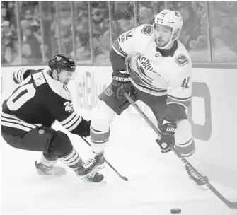  ??  ?? Canucks forward Alexander Burmistrov looks to pass while under pressure from Bruins winger Riley Nash during the second period in Boston on Thursday.