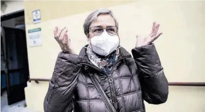  ?? CARLOS GIL ?? Una mujer se quita la mascarilla tras salir de un centro de salud de Cáceres, el primer día de uso obligatori­o.