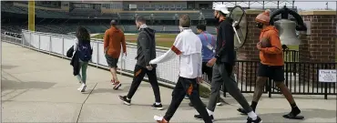  ?? DARRON CUMMINGS — THE ASSOCIATED PRESS ?? The Texas men’s basketball team walks around the concourse at Victory Field on Wednesday in Indianapol­is.