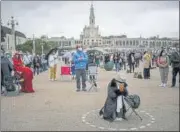  ?? AFP ?? Pilgrims maintain distance as they attend a pilgrimage at a shrine in Fatima in central Portugal.