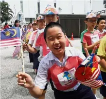  ??  ?? Unflagging patriotism: High-spirited Ivan Tan with his classmates from Class 6M, SJKC Heng Ee, Penang. The school held a vibrant National Day celebratio­n that included a parade and fun activities.