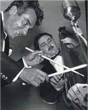  ?? DONALD N. EMMERICH / MILWAUKEE JOURNAL ?? Gene Krupa thumps out a tune on John Carbonne's bass at the Brass Rail, 744 N. 3rd St., on March 25, 1957.
