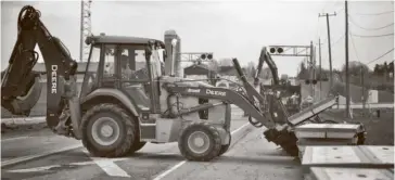  ?? Bill Atwood ?? Crews were busy this week repairing the road surface at the railway crossing on Arthur Street between St. Jacobs and Elmira, which closed the road for the week. See p. 23.