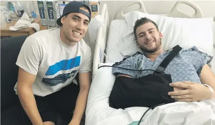  ?? — THE CANADIAN PRESS ?? Sheldon Mack, right, of Victoria poses with off-duty paramedic Jimmy Grovom from his hospital bed in Las Vegas on Wednesday. Mack was shot in the forearm and abdomen on Sunday.