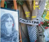  ?? MAJDI MOHAMMED/AP ?? Yellow tape marks bullet holes on a tree near a memorial on May 19 where journalist Shireen Abu Akleh was shot and killed in the West Bank city of Jenin.