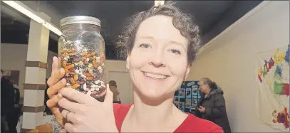  ?? KEVIN ADSHADE/THE NEWS ?? Greenhill farmer Cathy Munro holds up a jar of various seeds during Seedy Saturday.