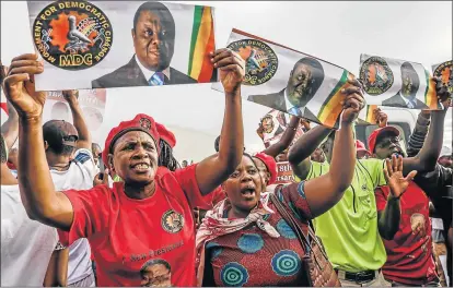  ?? Picture: AFP ?? EMOTIONAL MOMENT: Zimbabwe opposition party supporters cry and sing hymns as they hold placards picturing late Zimbabwe opposition leader Morgan Tsvangirai, when his body arrived at the internatio­nal airport in Harare on Saturday