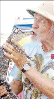  ?? RITA GREENE/MCDONALD COUNTY PRESS ?? Ken Henderson, the Alligator Man, kisses one of his alligators, Spike, at Jesse James Days in Pineville Aug. 10-13.