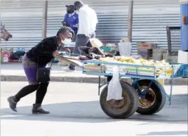  ??  ?? This woman is one of the few ladies who vend off pushcarts, a male-dominated business. She is seen here along 8th Avenue Extension in Bulawayo yesterday.